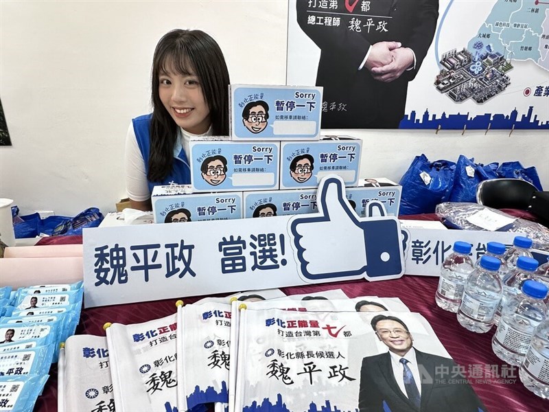 The daughter of Kuomintang's Changhua County magistrate candidate Wei Ping-cheng poses with Wei's campaign swag. CNA photo Oct. 18, 2026