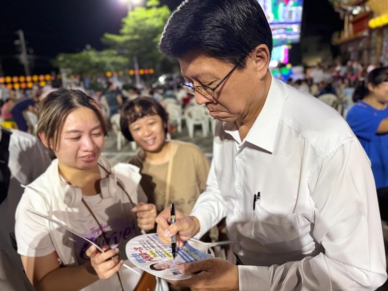 Kuomintang Tainan mayoral candidate Hsieh Lung-chieh signs a campaign fan. Photo courtesy of Hsieh’s office, Oct. 18, 2026.