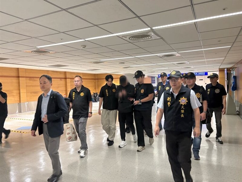 A suspect who allegedly fled to South Korea with another after taking part in a fatal assault in Kaohsiung last month is escorted by authorities upon arriving at Taoyuan International Airport. Photo courtesy of Kaohsiung City Police Department's Criminal Investigation Corps.