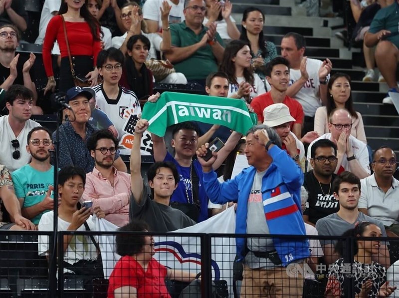 Seorang penonton di pinggir lapangan membentangkan kain dengan tulisan "Taiwan" pada hari Jumat, memberikan semangat dengan antusias untuk Lee Yang dan Wang Chi-lin. (Sumber Foto : CNA, 2 Agustus 2024)