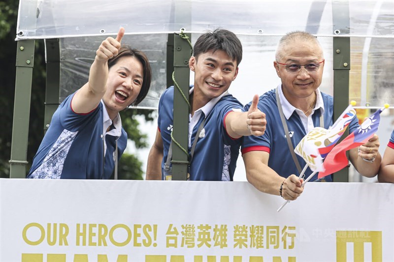 Judoka Lien Chen-ling (kiri), Yang Yung-wei (tengah) dan pelatih Yang, Liu Wen-teng, menyapa kerumunan di parade pada hari Jumat. (Sumber Foto : CNA, 16 Agustus 2024)