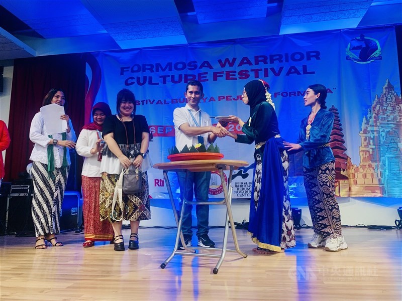 Kadir, analis bidang ketenagakerjaan KDEI (baju putih) sedang menerima tumpeng saat menghadiri sebuah acara kebudayaan di Taipei. (Sumber Foto : Dokumentasi CNA).