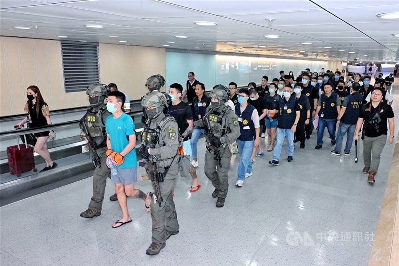 Sebagian dari lebih dari 100 warga Taiwan yang dideportasi dari Bali didampingi petugas Biro Investigasi Kriminal di Bandara Internasional Taoyuan. (Sumber Foto : CNA Taoyuan, 4 Juli 2024)