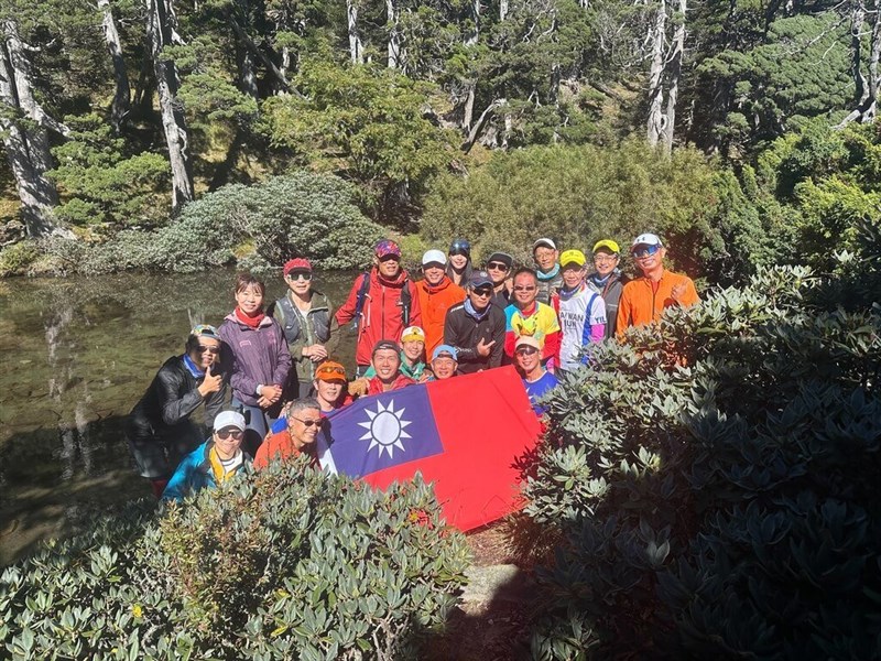 Tim pelari maraton yang dikenal sebagai "Pasukan Monyet" tiba di Danau Cui pada Kamis pagi dan membentangkan bendera kebangsaan untuk merayakan Hari Nasional. (Sumber Foto : Pasukan Monyet)