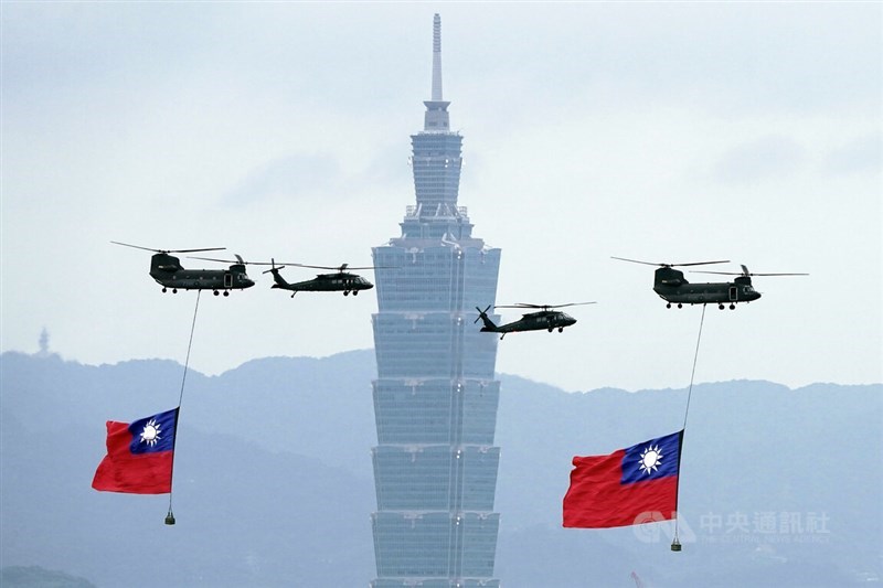 Dua helikopter transport CH-47SD (di kedua sisi), ditemani oleh dua helikopter UH-60M "Black Hawk" (tengah), membawa bendera nasional melintasi Taipei 101 Kamis dalam persiapan untuk acara perayaan utama di gedung Kantor Kepresidenan. (Sumber Foto : CNA, 10 Oktober 2024)