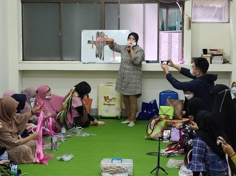 Tantri mengajar kerajinan membuat tas kepada PMI lainnya. (Sumber Foto : Tantri).