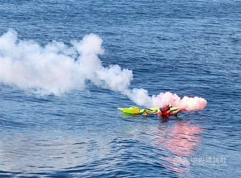 Seorang orang di air menembakkan suar untuk meminta bantuan pada latihan, Jumat.(Sumber Foto : CNA, 6 Desember 2024)