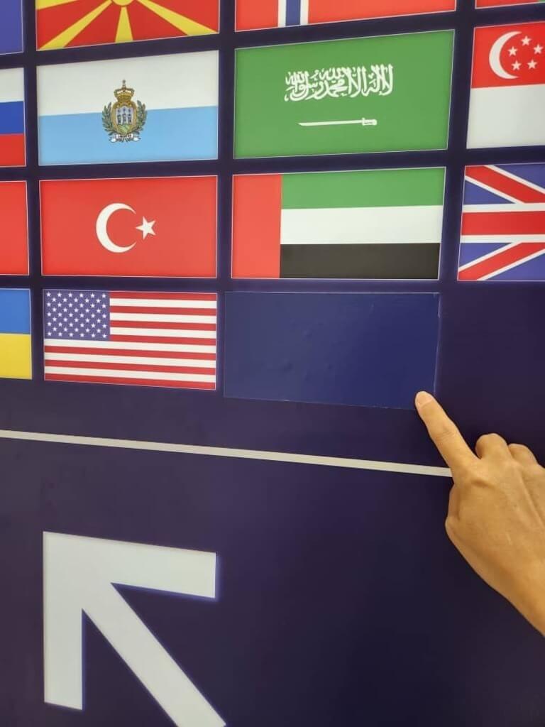 Sebuah jari menunjuk ke bendera negara Republik Tiongkok (Taiwan) yang ditutupi dengan selotip di bandara Malaysia untuk gerbang imigrasi otomatis. (Sumber Foto : Kontributor pribadi, 6 Des. 2024)