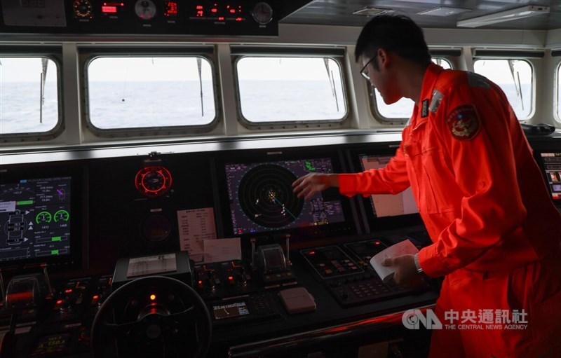 Seorang penjaga pantai memantau laut dengan peralatan di atas kapal Penjaga Pantai, Kamis. (Sumber Foto : CNA, 12 Desember 2024)
