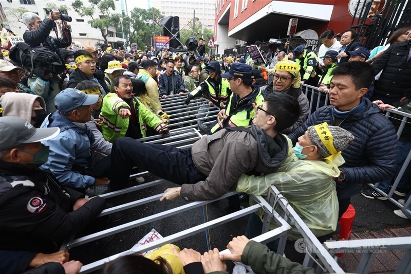 Sejumlah orang bentrok dengan polisi di luar gedung Yuan Legislatif di Taipei, Jumat. (Sumber Foto : CNA, 20 Desember 2024)