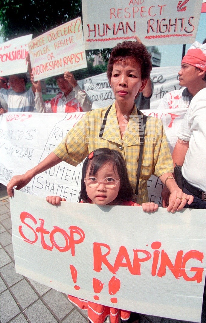 Seorang anak kecil memegang spanduk bertuliskan "Hentikan pemerkosaan!!!" dalam aksi di depan KDEI Taipei, 3 Agustus 1998. (Sumber Foto : Dokumentasi CNA)