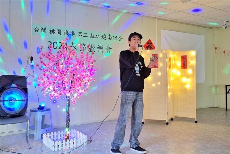 Seorang pria bernyanyi dalam kontes karaoke di sebuah asrama untuk pekerja migran Vietnam yang terlibat dalam proyek pembangunan terminal bandara di Taoyuan selama liburan Tahun Baru Imlek 2024. (Sumber Foto : Samsung C&T Corp.)