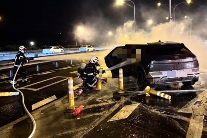 Pemadam kebakaran bekerja untuk memadamkan api di sebuah kendaraan yang mengalami kecelakaan di Jalan Nasional No. 1 di Taoyuan hari Sabtu. (Sumber Foto : Tangkapan layar sebuah video)