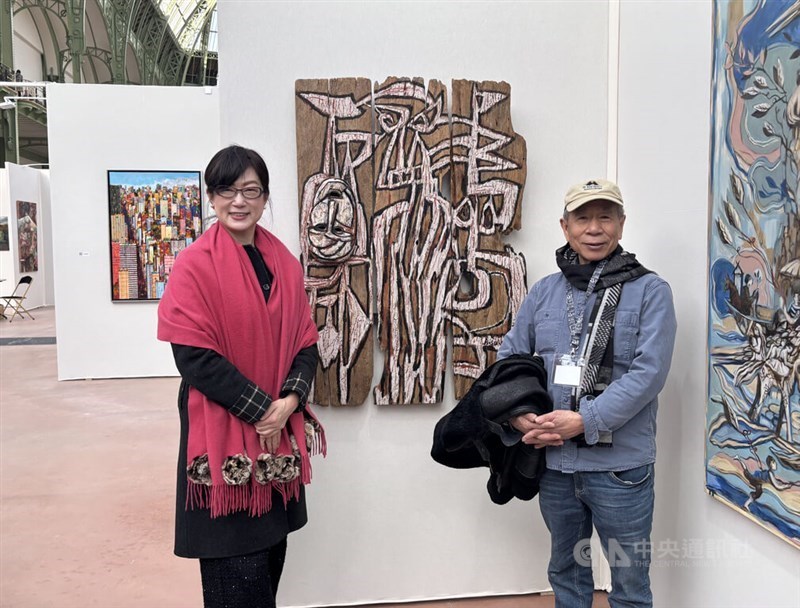 A-Sun Wu (kanan) berdiri di samping karyanya di sebuah pameran seni di Paris dan berpose dengan perwakilan Taiwan di Prancis, Hao Pei-chih, untuk difoto pada Selasa. (Sumber Foto : CNA, Februari 19 2025)