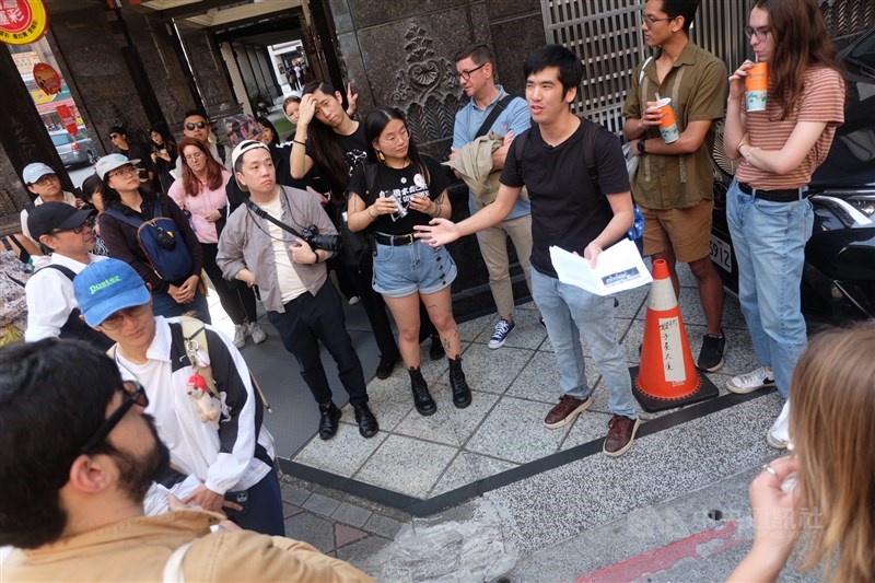 Brian Hioe dari New Bloom (kaos hitam membawa buku) menjelaskan sejarah insiden 228 kepada peserta tur. (Sumber Foto : CNA, 28 Februari 2025)