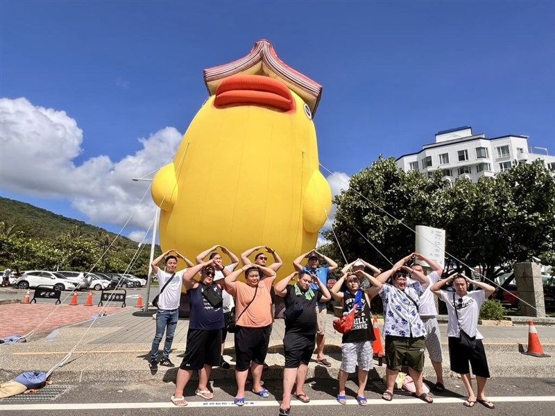 Sumo Master Shikoroyama Tsuneyuki dan para pegulat yang berkunjung dari Jepang berpose untuk foto bersama di depan karya seniman Taiwan A-Lei (阿咧) berjudul "Book Duck" yang dibuat sebagai instalasi tiup raksasa untuk pameran "There