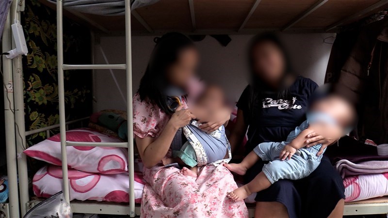 Dua pekerja migran memeluk anak-anak mereka di sebuah organisasi nirlaba di Taoyuan. (Sumber Foto : CNA)