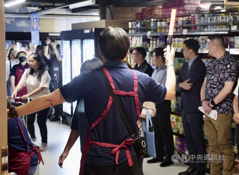 Seorang staf PX Mart mengarahkan orang-orang ke area penampungan yang telah ditentukan di dalam toko selama latihan di Taipei, Kamis. (Sumber Foto : CNA, 10 Juli 2025)