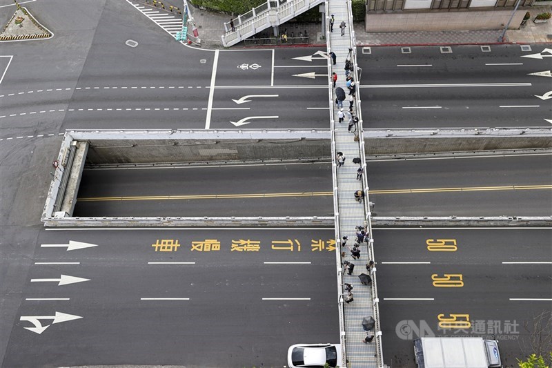 Sebuah jembatan penyeberangan diisi personel media sementara Jalan Zhongxiao Barat di bawahnya kosong. (Sumber Foto : CNA, 17 Juli 2025)