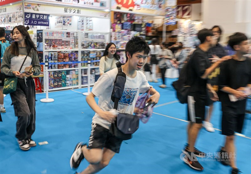 Seorang penggemar anime berlari masuk ke The Comic Exhibition saat dibuka di Taipei World Trade Center hari Kamis. (Sumber Foto : CNA, 24 Juli 2025)
