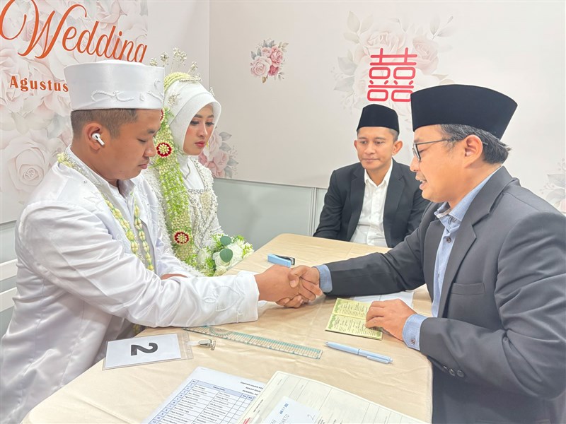 Kadir, analis bidang ketenagakerjaan KDEI (tengah) menjadi saksi pernikahan PMI. (Sumber Foto : KDEI, 24 Agu. 2025)