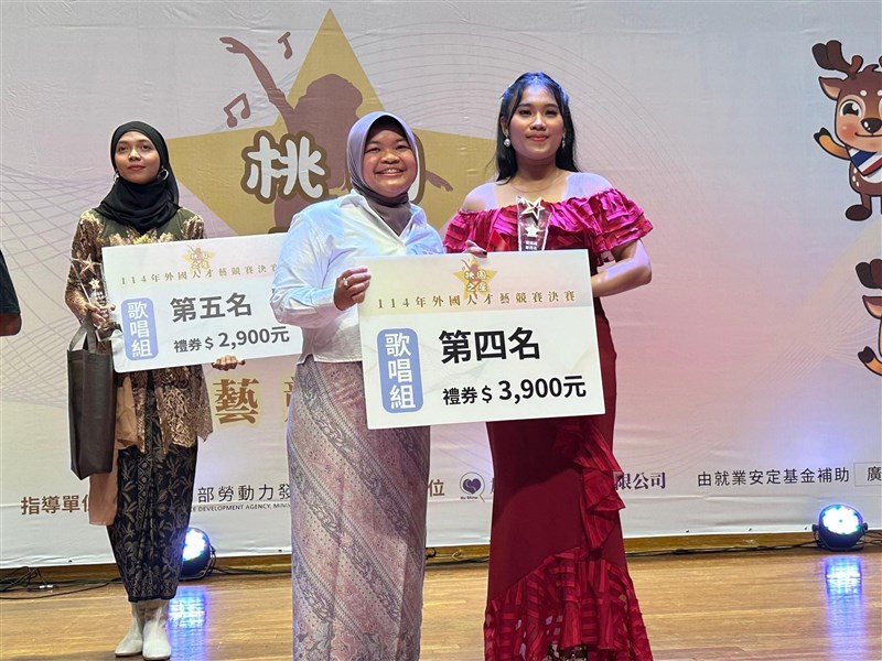 Mira Caliandra, analis bidang ketenagakerjaan KDEI yang hadir memberikan plakat bagi pemenang lomba menyanyi. (Sumber Foto : KDEI)