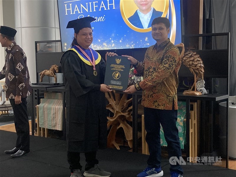 Kepala PKBM PPI Taiwan, Ananda Insan Firdausy (kanan) memberikan ijazah kepada salah seorang wisudawan di KDEI Taipei hari Minggu. (Sumber Foto : Dokumentasi CNA)