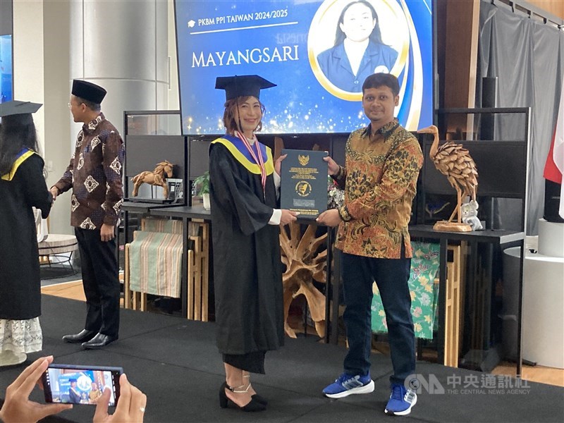 Kepala PKBM PPI Taiwan, Ananda Insan Firdausy (kanan) memberikan ijazah kepada salah seorang wisudawan di KDEI Taipei belum lama ini. (Sumber Foto : Dokumentasi CNA)