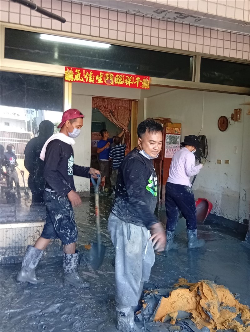 Kholis (mengenakan masker) saat membantu bersih-bersih di salah satu rumah yang terkena bencana. (Sumber Foto : PCINU)