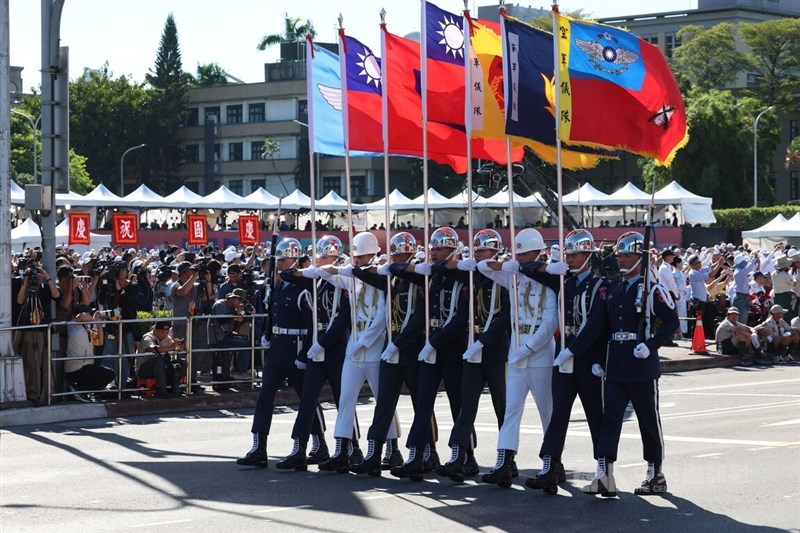 Pengawal Kehormatan Republik Tiongkok mempersembahkan bendera negara dan cabang-cabang militernya selama parade di depan Kantor Kepresidenan pada hari Jumat. (Sumber Foto : CNA, 10 Oktober 2025)