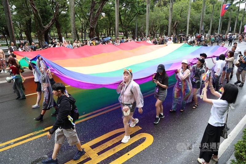 Orang-orang membawa bendera pelangi raksasa saat berbaris di jalan-jalan Taipei pada Sabtu. (Sumber Foto : CNA, 25 Oktober 2025)