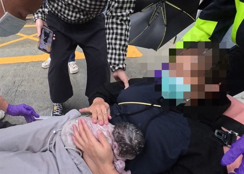 Seorang ibu menggendong bayi yang baru lahir setelah melahirkan di pinggir jalan di Kabupaten Yilan.  (Sumber Foto : Biro Pemadam Kebakaran Kabupaten Yilan)