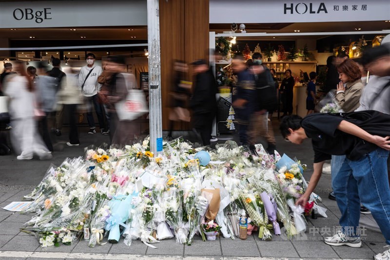 Seorang pria membungkuk untuk meletakkan buket bunga di luar Eslite Spectrum Nanxi dekat Stasiun MRT Zhongshan di Taipei pada 21 Desember, setelah insiden penikaman massal di Taipei pada 19 Desember. (Sumber Foto : Dokumentasi CNA)
