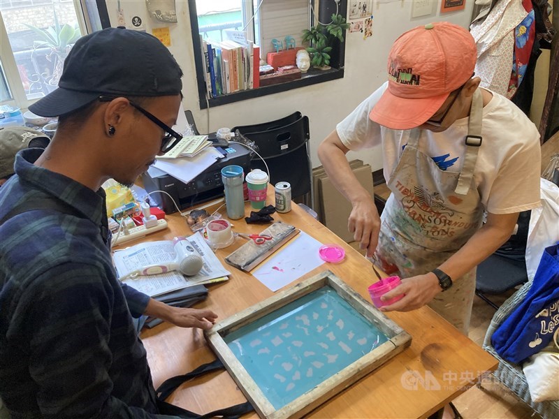 Syaiful Ardianto dari Cut and Rescue (kanan) memberi contoh praktik sablon dalam lokakarya "Bandung Fantasized" yang digelar di Open Contemporary Art Center Taipei, Minggu. (Sumber Foto : CNA, 15 Maret 2026)