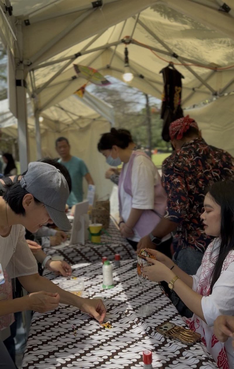 Salah satu pengunjung tertarik mencoba DIY membuat cincin dari pernak-pernik adat Dayak. (Sumber Foto : IDN Taiwan)