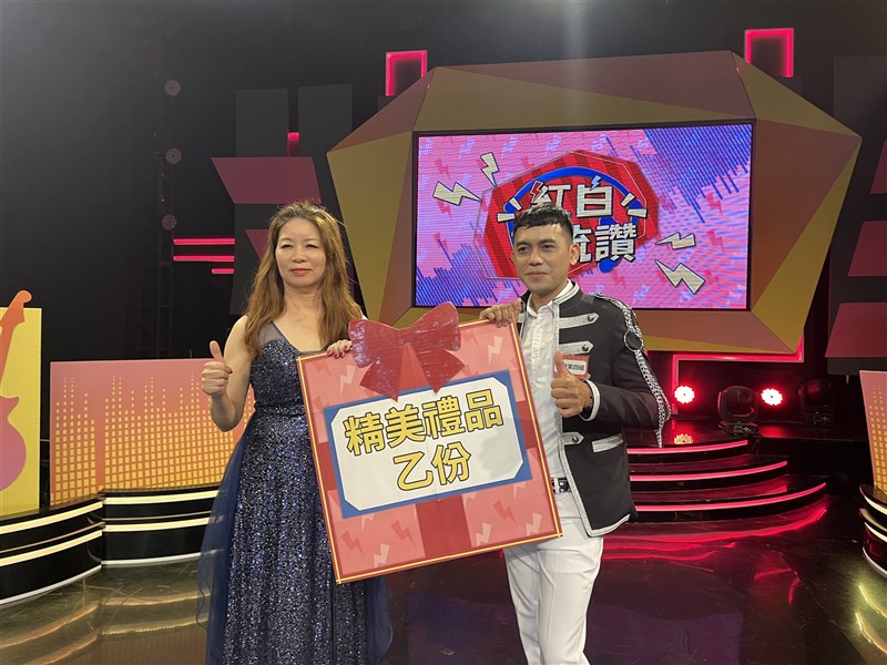 Yuan Roni berfoto bersama salah satu pengisi acara di Dali TV dengan memegang penghargaan grupnya yang memenangkan hadiah di suatu acara menyanyi dan talk show. (Sumber Foto : Yuan Roni).