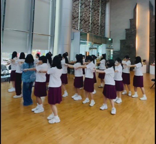 Video tangkapan layar saat Dewi mengajarkan para siswi untuk menari tarian Indonesia bersama. (Sumber Foto : Kartika Dewi)