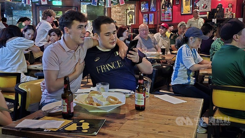 Para penonton saling berpelukan erat selama pertandingan, ditemani kudapan dan bir di sebuah bar di Taipei pada Kamis malam. (Sumber Foto : CNA, 12 Juni 2026)