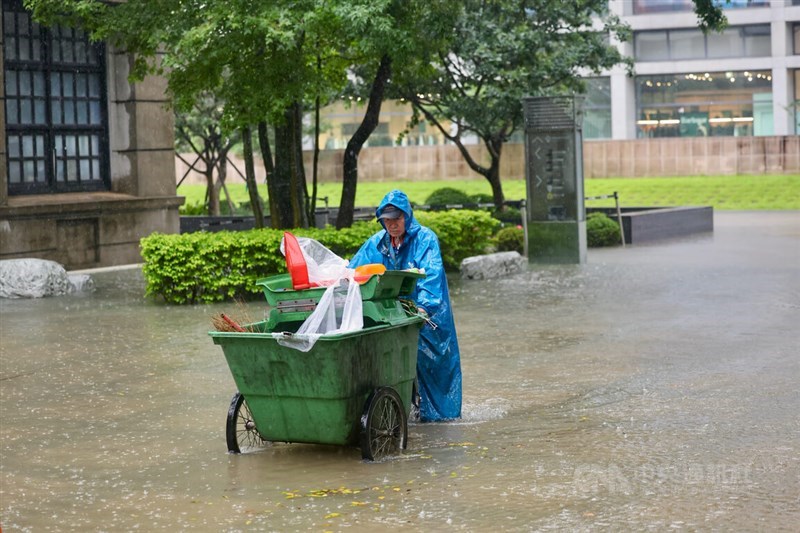 Seorang petugas kebersihan berjalan di bagian yang tergenang banjir di Distrik Songshan, Taipei, Kamis sore. (Sumber Foto : CNA, 18 Juni 2026)