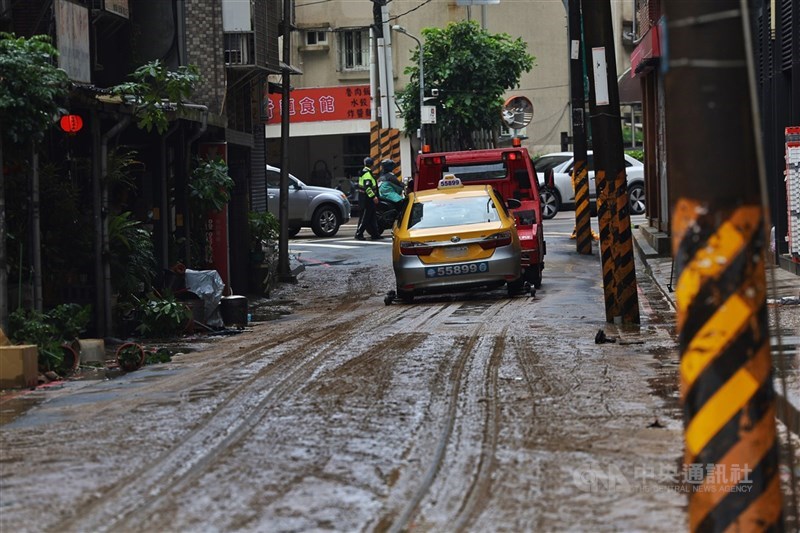 Sebuah mobil diderek di Distrik Neihu, Taipei setelah air banjir surut, Kamis. (Sumber Foto : CNA, 25 Juni 2026)