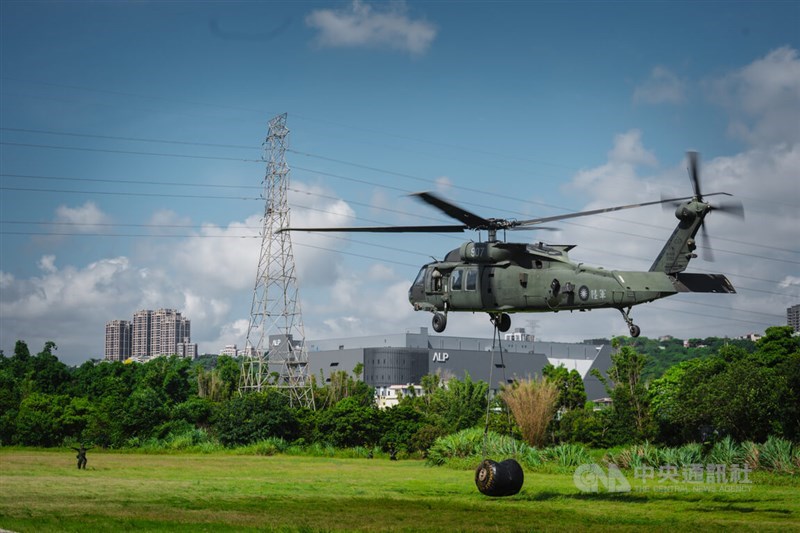Sebuah helikopter UH-60M Black Hawk milik Angkatan Darat melayang di atas sebuah ladang di Distrik Daxi, Taoyuan, Selasa sambil menurunkan kantong bahan bakar aviasi berkapasitas 500 galon. (Sumber Foto : CNA, 14 Juli 2026)