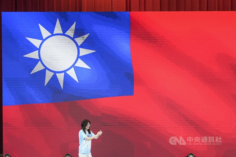 Cheng bertepuk tangan untuk para kandidat pemilu lokal KMT saat berjalan melewati gambar raksasa bendera nasional pada pertemuan di Taipei hari Sabtu. (Sumber Foto : CNA, 25 Juli 2026)