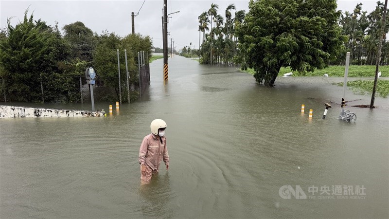 Seorang petani buah berdiri di tengah genangan banjir di Kecamatan Wandan, Kabupaten Pingtung, pada hari Senin. (Sumber Foto : CNA, 24 Agustus 2026)