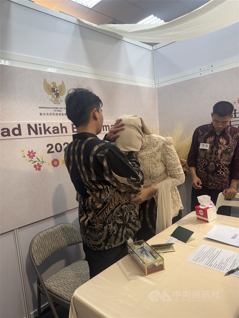 Seorang istri sedang mencium tangan suaminya pertama kali setelah disahkan pernikahannya di bilik pernikahan KDEI Taipei. (Sumber Foto : CNA, 30 Agustus 2026) 