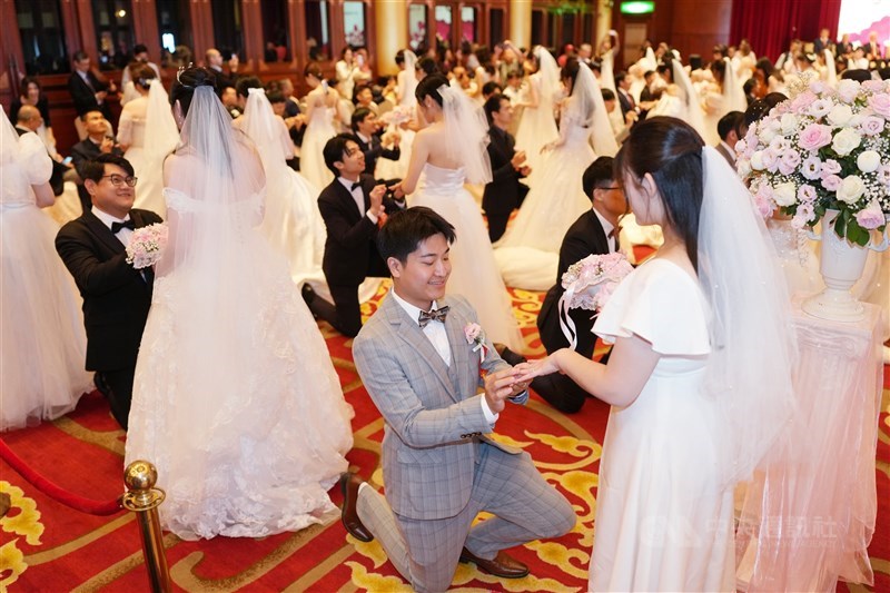 Para pengantin pria memeragakan kembali lamaran pernikahan mereka selama acara pernikahan massal yang diselenggarakan oleh Chunghwa Telecom di Grand Hotel, Taipei pada Minggu. (Sumber Foto : CNA, 13 September 2026)