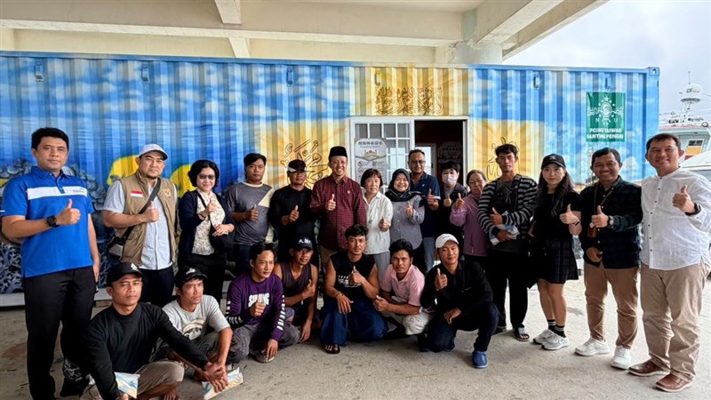Kepala KDEI, Arif Sulistiyo (mengenakan peci dan kemeja merah) berfoto bersama PMI dan ABK di depan kontainer yang dijadikan musala. (Sumber Foto : KDEI Taipei).
