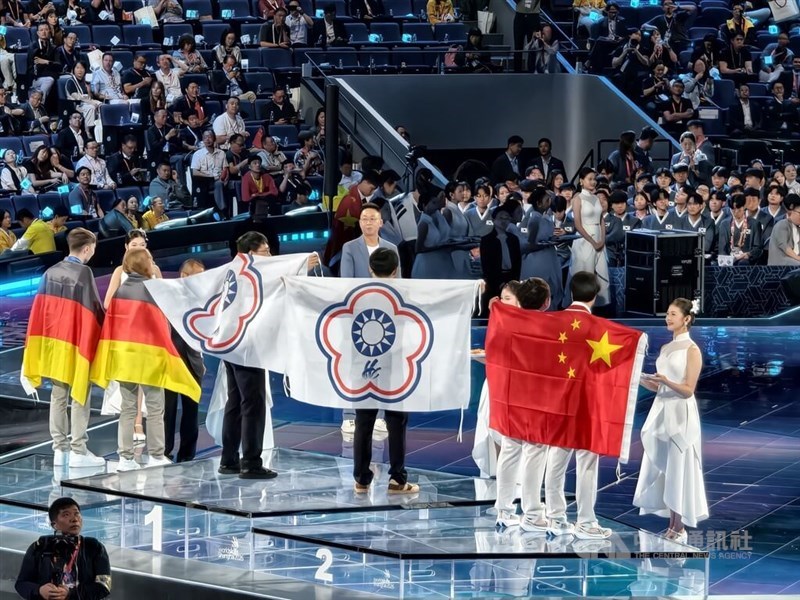 Chiu Yu-hsiang dan Yang Yong-xu memamerkan bendera Chinese Taipei setelah memenangkan medali emas Cyber Security dalam kompetisi Teknologi Informasi dan Komunikasi di WorldSkills Shanghai 2026 pada Minggu. (Sumber Foto : CNA, 27 September 2026)