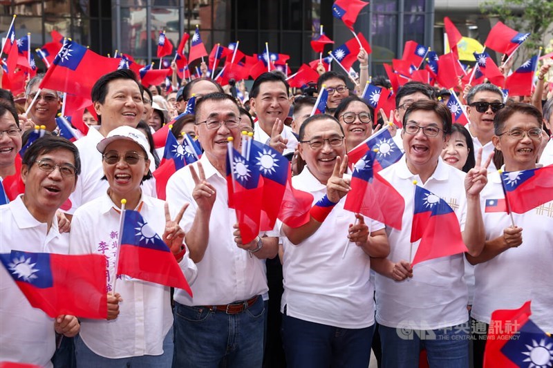 Wali Kota New Taipei, Hou Yu-ih, melambaikan bendera negara saat berpose untuk foto bersama dengan yang lainnya di pusat administrasi kedua di Distrik Sanchong pada Sabtu. (Sumber Foto : CNA, 10 Oktober 2026)