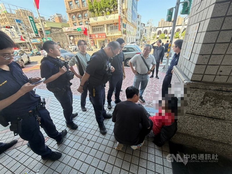 Seorang pria (berbaju merah) yang diduga membunuh bibinya di Distrik Xinzhuang, New Taipei, dikelilingi oleh polisi setelah penangkapannya di Taoyuan pada hari Senin. (Sumber Gambar : CNA)