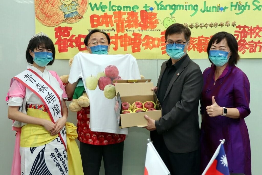 三村申吾青森県知事（左から2人目）からリンゴを贈られる高雄市の教育関係者ら＝同市政府
